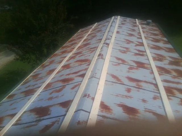 Rusted metal roof panels with new wood purlins before replacement — Storm Damage Roof Repair in Garnerville by Roofing Brothers