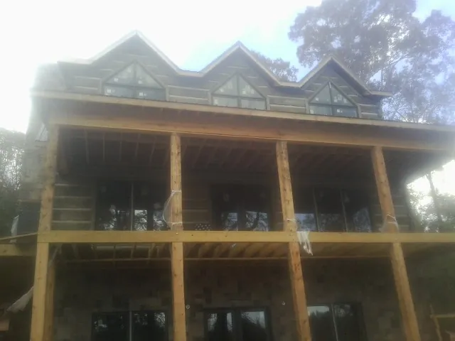 Dormers and porch framing on a large log home under construction — Roof Coating work by our crew in Garnerville