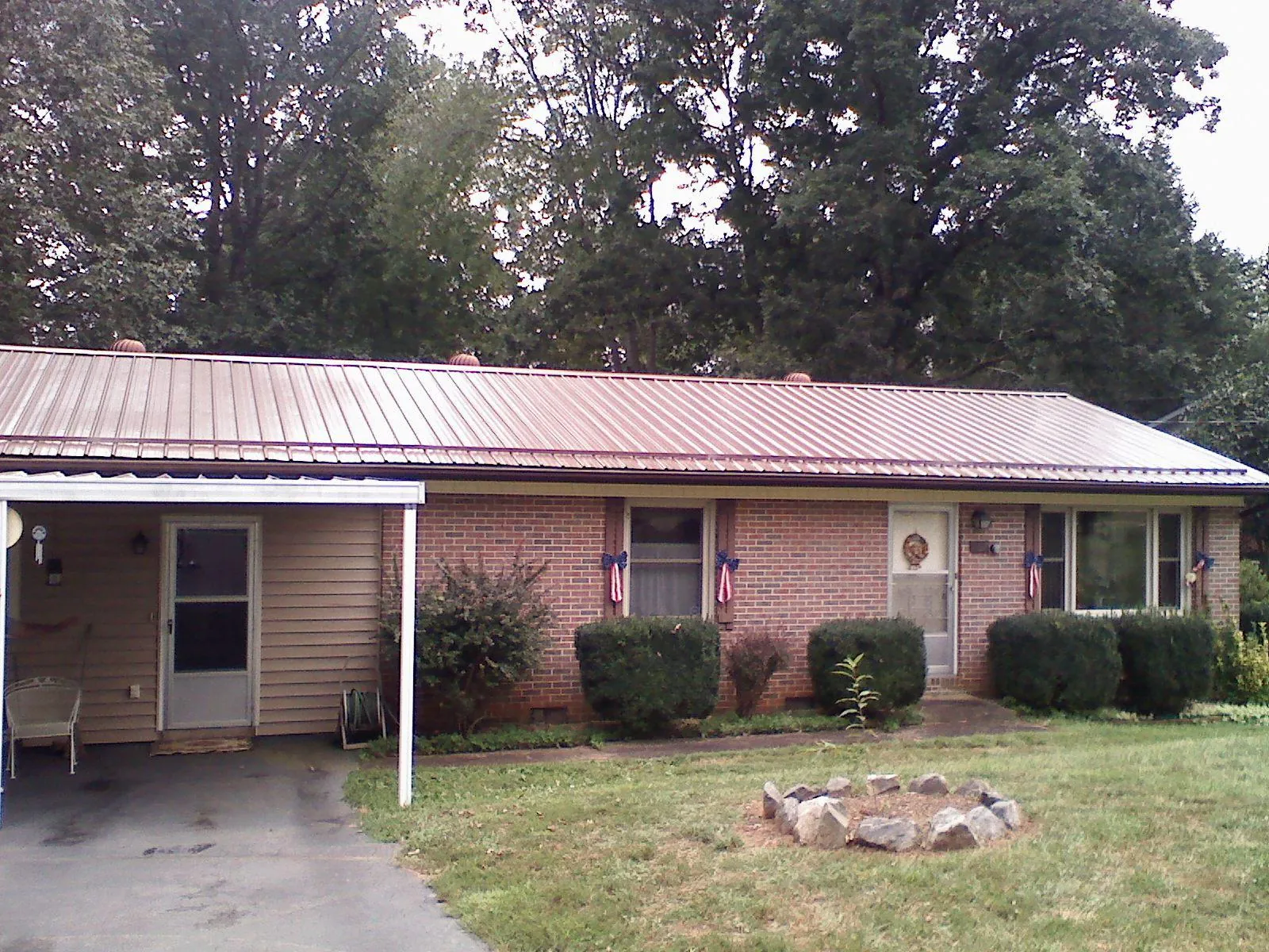 Bronze metal roof and carport on a brick ranch home — Roof Repair work by our crew in Garnerville